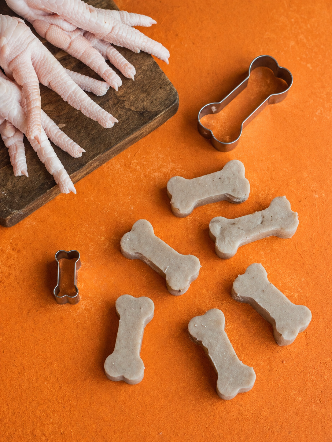 Patas de pollo junto a las gomitas de colágeno con forma de hueso